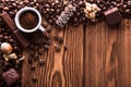 Roasted coffee beans, chocolate, candy, nuts, cup and the place for inscriptions on wooden background Royalty Free Stock Photo