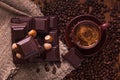 Roasted coffee beans, chocolate, nuts and cup on the wooden background