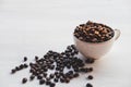 .Roasted coffee beans in a coffee cup on a white table Royalty Free Stock Photo