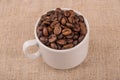 Roasted coffee beans in coffeecup on burlap Royalty Free Stock Photo