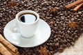 Roasted coffee beans with a cup on a saucer with an espresso drink with cinnamon and anise Royalty Free Stock Photo