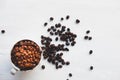 Roasted coffee beans in a coffee cup on a white table Royalty Free Stock Photo
