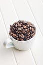 Roasted coffee beans in coffee cup on white table Royalty Free Stock Photo