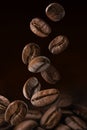 Roasted coffee beans falling on pile. Dark colors Royalty Free Stock Photo