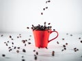 Roasted coffee beans, falling into a red coffee cup, on white background Royalty Free Stock Photo