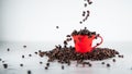 Roasted coffee beans, falling into a red coffee cup, on white background Royalty Free Stock Photo