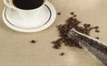 Roasted coffee beans in a glass bottle and a Cup of coffee on linen cloth Royalty Free Stock Photo