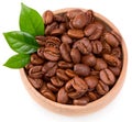 Roasted coffee beans with green leaves in wooden bowl isolated on white background. Clipping path and full depth of field. Top vie Royalty Free Stock Photo