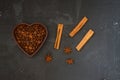 Roasted coffee beans in heart shaped bowl on black stone table. Love coffee concept. Top view flat lay with copy space. Royalty Free Stock Photo