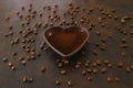 Roasted coffee beans in heart shaped bowl on dark background. Royalty Free Stock Photo