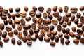 Roasted coffee beans neatly scattered in a wide strip on a white background