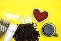 Roasted coffee beans with powder and disposable cups and sugar and heart shape on yellow background. love coffee concept Royalty Free Stock Photo