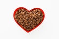 Roasted coffee beans in red heart shaped plate, white background Royalty Free Stock Photo