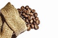 Roasted coffee beans scattered from burlap bag isolated on white background. Copy space Royalty Free Stock Photo