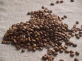 Roasted coffee beans scattered on a burlap napkin Royalty Free Stock Photo