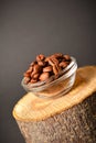 Roasted coffee beans served in glass bowl on wooden log