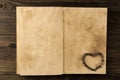 roasted coffee beans in shape of heart on old vintage open book. Menu, recipe, mock up. Royalty Free Stock Photo