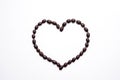 Roasted coffee beans in a shape of a heart on white background Royalty Free Stock Photo