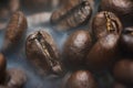 Roasted coffee beans with smoke. Coffee Background Royalty Free Stock Photo