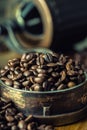 Roasted coffee beans spilled freely on a wooden table. Coffee beans in a dish for ground coffee. Royalty Free Stock Photo