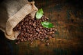 Roasted coffee beans on vintage wood with leaves Royalty Free Stock Photo