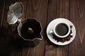 Roasted coffee beans with a white cup of espresso on a dark wooden table, rustic, top view Royalty Free Stock Photo