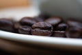 Roasted coffee beans with white cup on white wood table. coffee Royalty Free Stock Photo