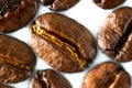 Roasted coffee beans on white milk background. Coffee beans in milk. Top view macro shot of arabica, robusta and iberica coffee se