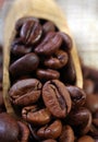 Roasted coffee beans in a wooden scoop close-up. selective focus Royalty Free Stock Photo