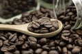 Roasted coffee beans in wooden spoon and spread on black table with white coffee cup Royalty Free Stock Photo