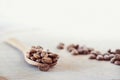 Roasted coffee beans on a wooden table with wooden spoon on a white background, isolated, close up Royalty Free Stock Photo