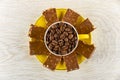 Coffee beans in yellow cup, pieces of chocolate on saucer on table. Top view Royalty Free Stock Photo