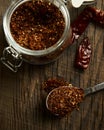 Roasted dry chili pepper powder in jar. Dried chilli on background. Top view. Royalty Free Stock Photo
