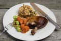 Roasted duck with apple and herb stuffing and vegetables