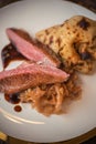 Roasted duck breast with cabbage and pancake served on white plate with glass of wine, winter and seasonal food, product photograp