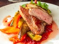 Roasted duck breast with vegetable garnish. The meat is sliced into portions and sprinkled with cranberry berry sauce Royalty Free Stock Photo