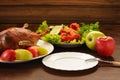 Roasted duck with fresh vegetables and apples and empty plate on