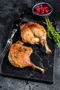 Roasted duck leg confit with cranberrie sauce. Black background. top view