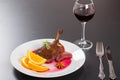 Roasted duck leg on platter with glass of red wine Royalty Free Stock Photo