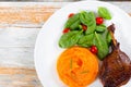 Roasted duck leg on platter with spinach and pumpkin porridge Royalty Free Stock Photo