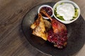 Roasted duck meat with green vegetable cucumber salad with white cream and berry sauce on black plate. Paleo, keto diet Royalty Free Stock Photo