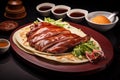 Roasted duck with pancakes on a wooden plate with soy sauce and pickles