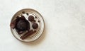 Chocolate muffin, candies and cinnamon sticks on white plate