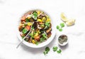 Roasted eggplant, sweet tomato and cilantro mediterranean style salad on light background, top view. Vegetarian food