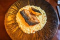 Roasted fish fillet on risotto on decorative plate on restaurant table