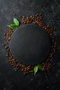 Roasted fragrant coffee beans on a black stone background. Top view. Free space for your text