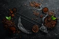 Roasted fragrant coffee beans on a black stone background. Top view.