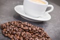 Roasted fragrant coffee grains and coffee with milk in background