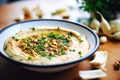 roasted garlic hummus with cloves around the bowl edge Royalty Free Stock Photo