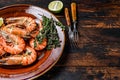 Roasted giant tiger shrimps Prawns on a plate. Dark wooden background. Top view. Copy space